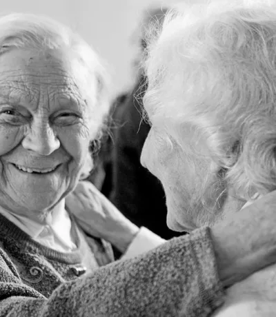 grayscale photo of woman in sweater smiling